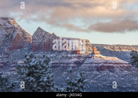 Sunrise leuchtet Sedonas berühmten roten Felsen nach Schneefall. Frischer Schnee Highlights der Gesteinsschichten. Stockfoto