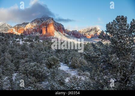Thunder Mountain beleuchtet durch die ersten warmen Sonnenstrahlen Sonnenaufgang nach einer nächtlichen Schneefall, Sedona, Arizona. Gestochen scharfe, klare winter Licht. Stockfoto