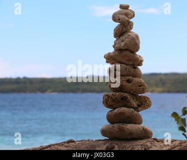 Ein Haufen von Steinen sitzen neben dem Meer. Stockfoto