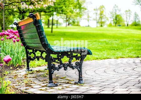 Leere Bank im grünen Plaines Emmanuel Morgen im Sommer mit rosa oder lila Tulpe Blumenbeet in Québec (Stadt) Stockfoto