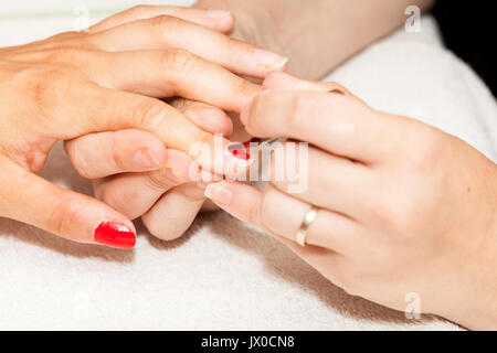 Festlegung Nagellack auf die Hände einer Frau Stockfoto