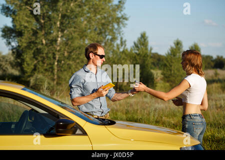 Paar in der Liebe. Off-road Abenteuer. Das Mädchen gibt dem Freund die Schlüssel der Zündung. Sie stehen mit dem Auto. Stockfoto