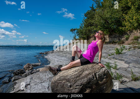 Auf einem felsigen Ufer des Lake Champlain gehen und mit Blick auf den See Stockfoto