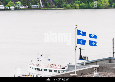 Blau Quebec Flagge auf dem Dach mit Blick auf die Yacht Schiff am St. Lawrence River Stockfoto