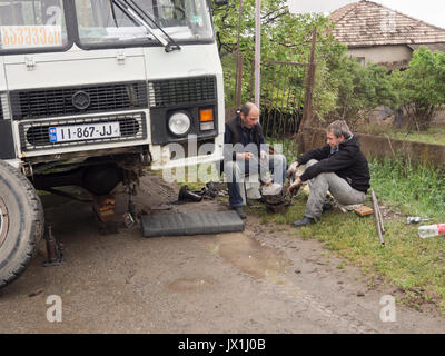 Fahrt mit dem Bus im öffentlichen Verkehr auf Straßen mit Schlaglöchern in Georgien kann eine Herausforderung sein. Hier Treiber sind zur Festsetzung einer Lenkung der Vorderachse Stockfoto