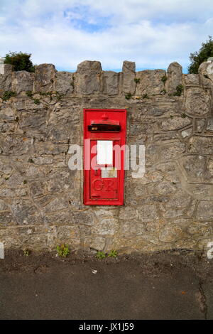 Eine alte George Rex Letter Box in einer Wand entlang der Seite des Dorfes Hauptstraße, jetzt gesperrt und mit einem nahe gelegenen Ersatz an Ort und Stelle stillgelegt. Stockfoto