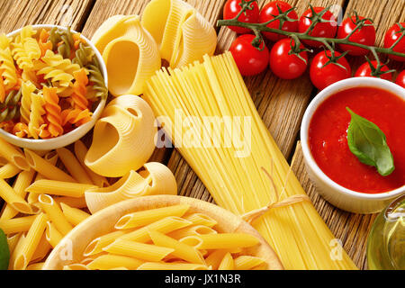 Verschiedene Nudeln und Tomaten passata auf hölzernen Hintergrund Stockfoto