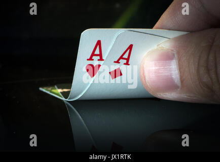 Ein Paar Asse auf schwarzem Hintergrund in der Hand von puckerman. Das Spiel zu gewinnen. Die Karten in gute Kombinationen. Stockfoto