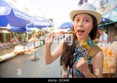 Jugendliche Reisende Einkauf auf dem schwimmenden Markt Amphawa Straße und Kauf von köstlichen Fleisch gegrillte Spieße in der Reise von Thailand Sommerferien Stockfoto