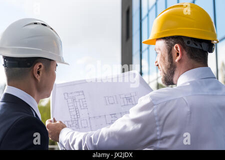 Rückansicht des professionellen Architekten in harte Hüte über Projekt Stockfoto