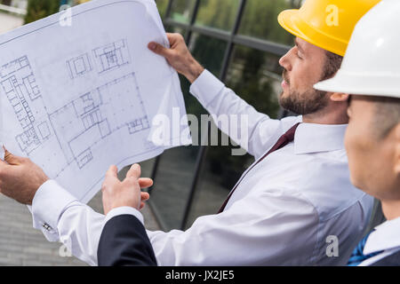 Seitenansicht der professionellen Architekten in harte Hüte diskutieren Projekt, erfolgreiche Geschäftsleute Konzept Stockfoto