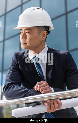 Portrait von professionellen Architekten im harten Hut holding Blueprint Stockfoto