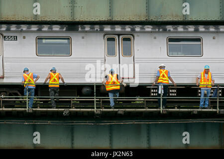 New York City MTA Arbeitnehmer in Warnwesten arbeiten ein Laufsteg in der Nähe der U-Bahn erhöht Titel in Coney Island, Brooklyn, New York City. Stockfoto