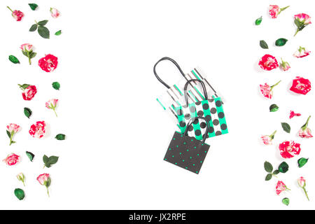 Drei Papiertragetaschen und Rosenblüten Frame auf weißem Hintergrund. Ansicht von oben Stockfoto
