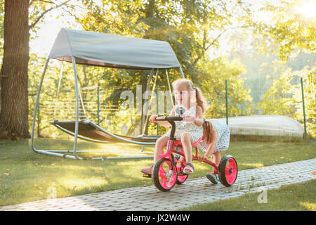 Süße kleine blonde Mädchen auf einem Fahrrad im Sommer. Stockfoto