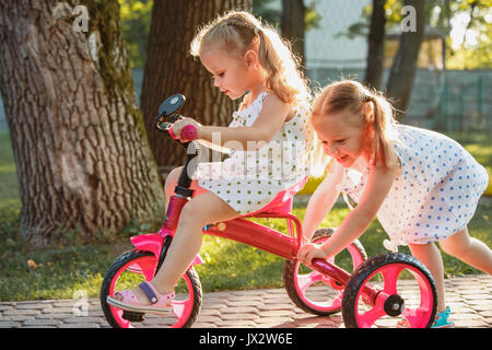 Süße kleine blonde Mädchen auf einem Fahrrad im Sommer. Stockfoto