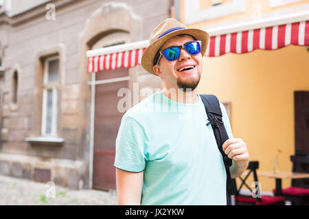 Schöne bärtige Tourist mit Rucksack ist das Reisen über die Stadt. Stockfoto