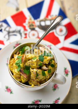 Coronation chicken im Tee Tasse und Royal Guard und Union Jack serviette Stockfoto