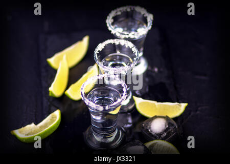 Silber Mexikanischen tequila Schüsse mit Salz und Limette auf dunklem Schiefer Hintergrund. Close-up. Tequila. Tequila shot. Stockfoto