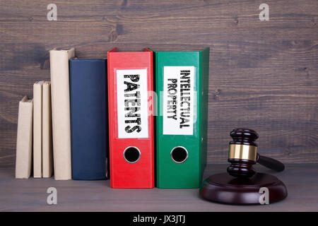 Patente und geistiges Eigentum. Holz- Hammer und Bücher im Hintergrund. Recht und Gerechtigkeit Konzept. Stockfoto