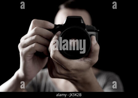 Nahaufnahme eines jungen kaukasischen Mann schießen Sie ein Foto mit einer Spiegelreflexkamera Stockfoto