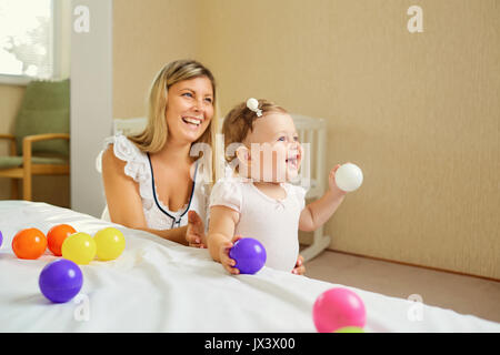 Mama spielt mit dem Baby im Zimmer im Innenbereich. Stockfoto