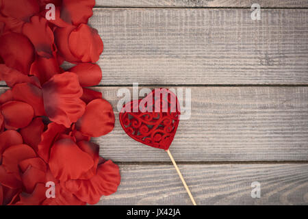 Herz auf Stick und Rosenblättern Stockfoto