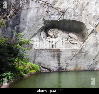 Sterbende Löwendenkmal (Deutsch: lowendenkmal) auf dem Gesicht von Stone Cliff mit dem Teich im Vordergrund in Luzern, Schweiz, Europa. Stockfoto