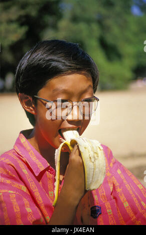 10 -12 Jahre alte asiatische Tween junge Essen banana © Myrleen Pearson