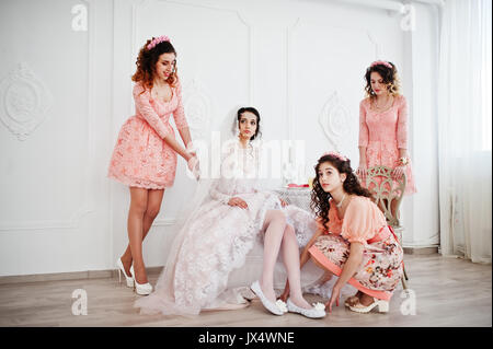 Brautjungfern helfen Braut ihren Schuhe auf und machen Sie sich bereit für ihre Hochzeit. Stockfoto