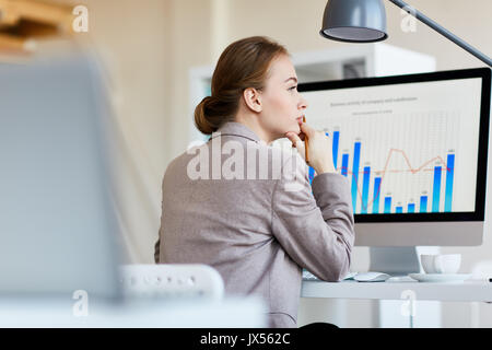 Nachdenklich Mitarbeiter Analyse von Statistiken Stockfoto