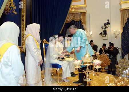 Johor Bahru, Malaysia. 14 Aug, 2017. HANDOUT-Prinzessin Tunku Tun Aminah Sultan Ibrahim und Niederländisch - geborene Dennis Muhammad Abdullah (beide C) während ihrer Hochzeit am 14. August 2017 in Johor Bahru, Malaysia. Das königliche Paar haben ihren ersten öffentlichen Auftritt als Mann und Frau auf der Treppe des historischen Istana Besar (Grand Palace). (Achtung Redaktionen: Für redaktionelle VERWENDUNG AUSSCHLIESSLICH IN ZUSAMMENHANG MIT DER AKTUELLEN BERICHTERSTATTUNG/obligatorischer Gutschrift) Foto: Royal Pressestelle Johor/dpa/Alamy leben Nachrichten Stockfoto