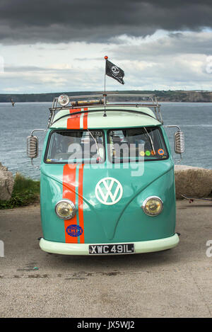 Ein vintage VW Wohnmobil an der Küste von Cornwall geparkt. Stockfoto