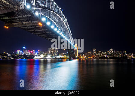 Buntes Licht Reflexion an der Sydney Harbour Bridge bei Nacht vom Circular Quay, Sydney, Australien Stockfoto