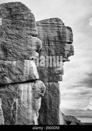 Mühlstein grit Felswände mit gesichtszüge an Burbage Flanke in der Nähe von Hathersage im Derbyshire Peak District (monochrom) Stockfoto