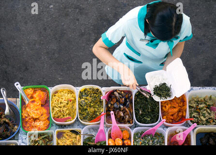 Kota Kinabalu, Malaysia - 1. August 2017: Direkt über dem Schoß einer Frau die Wahl eines Essen im self service Street Food stall in Kota Kinabalu, Sabah Stockfoto