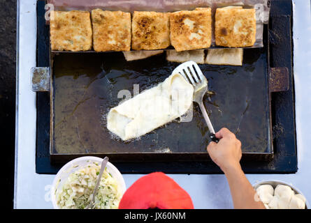 Draufsicht eines Mannes hand Kochen Gemüse Martabak Jawa in Kota Kinabalu City offenen Markt in Sabah Borneo. Martabak Jawa auch bekannt als gefüllte Pfannkuchen Stockfoto