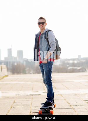 glücklich Jüngling oder Teenager Reiten auf longboard Stockfoto