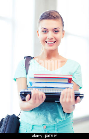 Student mit Ordnern und Schultasche in der Schule Stockfoto