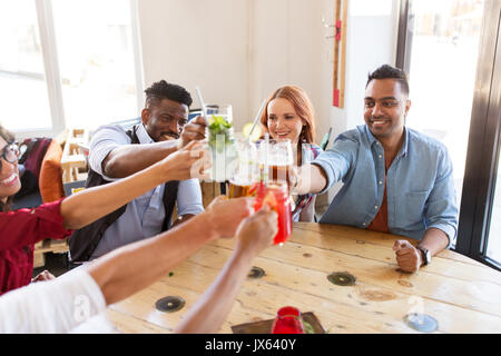 Freunde, die klirrende Gläser mit Getränken im restaurant Stockfoto