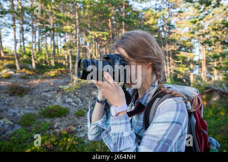 Junge Frau Fotos im Herbst Wald mit Kamera Stockfoto