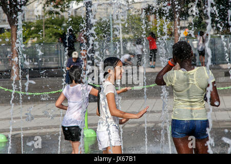 Kinder sind immer total nass beim Spielen mit einem Brunnen an einem heißen Sommertag. Stockfoto