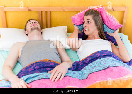 Frau schlaflose und wütend, weil ihr Mann im Bett schnarchen Stockfoto