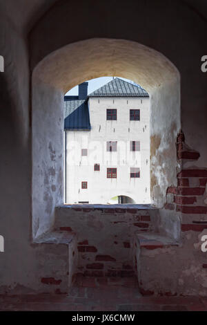 Eines der Gebäude der Burg Turku durch ein altes Fenster gesehen. Das Schloss ist mittelalterlich und es hat viele Gebäude in verschiedenen Epochen. Stockfoto