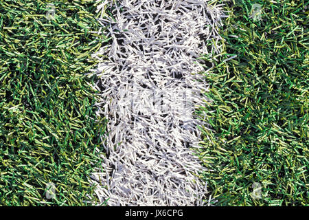Künstliche grüne Gras mit weißem Streifen auf dem Fußball-Feld. Weiße Linie auf grünem Gras ein Feld von Spielen. Gefälschtes Gras auf Sportplätze für Fußball verwendet, Bas Stockfoto