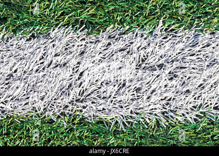 Künstliche grüne Gras mit weißem Streifen auf dem Fußball-Feld. Weiße Linie auf grünem Gras ein Feld von Spielen. Gefälschtes Gras auf Sportplätze für Fußball verwendet, Bas Stockfoto