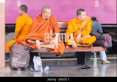 Mönche saßen auf einer Plattform Bank warten auf einen Zug, Hua Lamphong railway station, Bangkok, Thailand Stockfoto