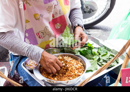 Frau Straßenhändler, Miang kam ein traditioneller Thai Snack auf Yaowarat Road, CHinatown, Bangkok Stockfoto