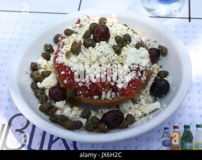 Traditionelle griechische Salat aus Kreta Insel namens Ntakos. Getrocknetes Brot mit Tomaten, Feta Käse, Oregano, kapari und natives Olivenöl extra Stockfoto