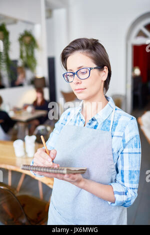 Hübsche Kellnerin Eingehüllt in Arbeit Stockfoto